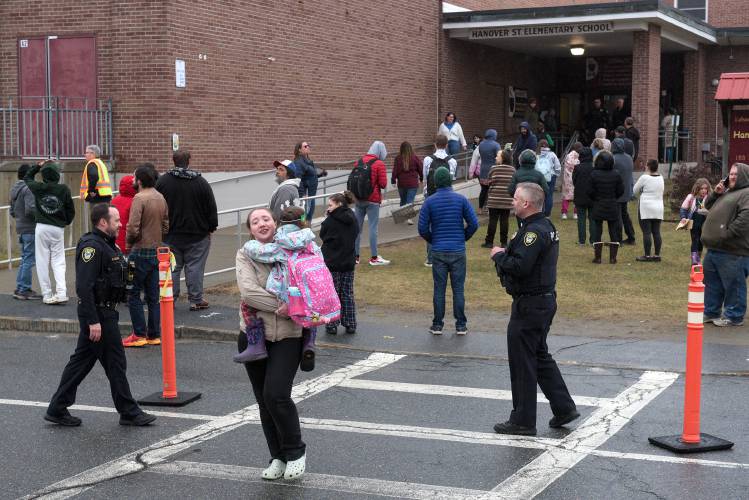 Mikayla Thibodeau, of Lebanon, carries her daughter Alyanna, 6, to the car after waiting about 90 minutes as Hanover Street School was locked down as Lebanon, N.H., Police addressed a man having a mental health crisis nearby on Friday, March 15, 2024. 