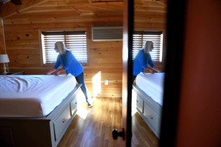 Kathryn Callum, of Unity, N.H., makes the beds in the cottage she and her husband bought in 2021 on Mountainview Lake in Sunapee, N.H. on Thursday, Feb. 8, 2024. (Valley News - Jennifer Hauck) Copyright Valley News. May not be reprinted or used online without permission. Send requests to permission@vnews.com.