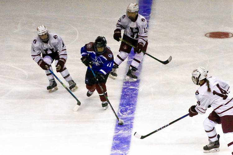 Oyster River-Portsmouth's Meagan Rinko is surrounded by Hanover's Hannah Gardner (3), Rory Seelig (12) and Julia Lawe during the NHIAA Division I teams' championship game on March 9, 2024, at SNHU Arena in Manchester, N.H. Hanover won, 2-1. (Valley News - Tris Wykes) Copyright Valley News. May not be reprinted or used online without permission. 