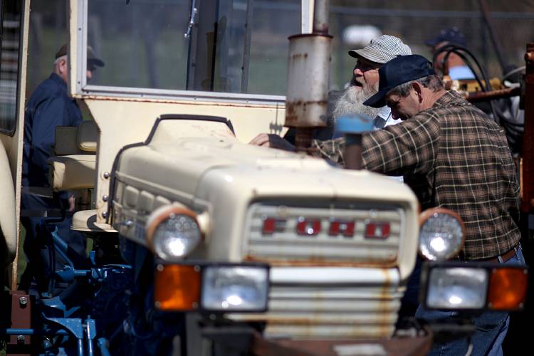 Ted Greene, left, a farmer from Sebago, Maine, and Richard Wing, a logger from Gorham, Maine, investigate a 1966 Ford Utility 3400 tractor. 