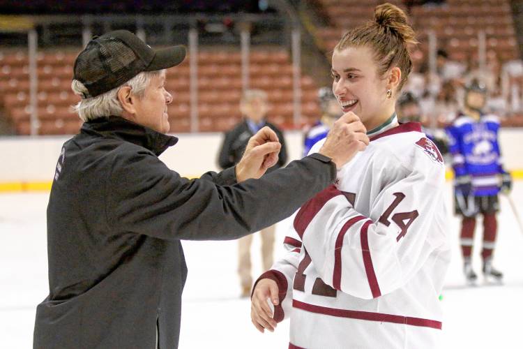 Hanover High girls hockey coach John Dodds drapes a championship medal around the neck of forward Julia Lawe following the Bears' 2-1 defeat of Oyster River-Portsmouth on March 9, 2024, at SNHU Arena in Manchester, N.H. (Valley News - Tris Wykes) Copyright Valley News. May not be reprinted or used online without permission. 