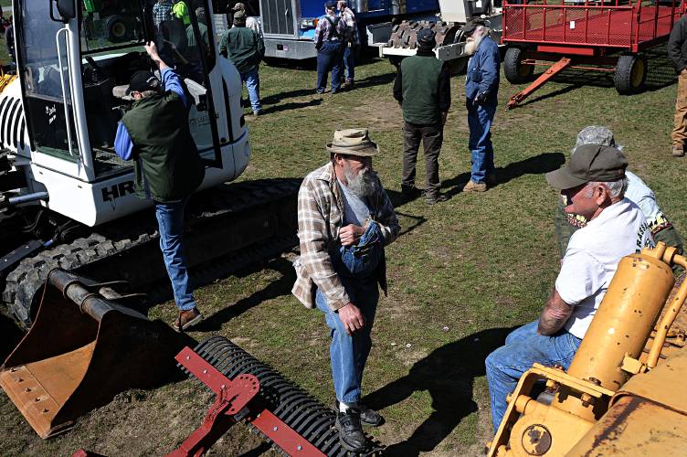 Henry Connolly of Brookfield, Vt., middle, talks with Ken Blaisdell of East Randolph, Vt., as auction-goers look over the offerings at CW Gray's annual spring auction in Fairlee, Vt., on Saturday, April 27, 2013. Blaisdell said he didn't have his eye on anything in particular, but would bid on, 