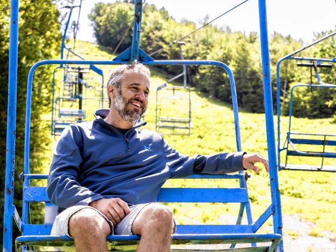 Jonathan Hunt sits on the 70s-era chairlift at Whaleback Mountain on Thursday, July 20, 2023 in Enfiled, New Hampshire.