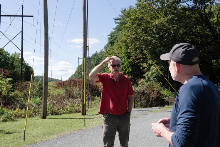 Brad Goedkoop, left, talks with fellow Wilder resident Tim Brennan, right, about the use of a chemical defoliant in the National Grid power line right-of-way, which is also leased by the Town of Hartford as a trail to connect the north and south ends of Kilowatt Park, in Wilder, Vt., on Thursday, August 31, 2023. 