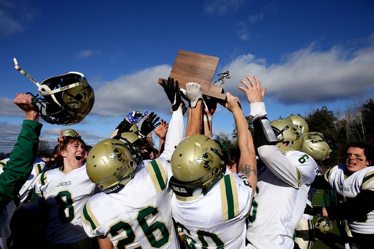 Windsor hoists the hardware following their 36-0 shutout of Woodstock in the Division III state championship in Rutland, Vt., on Nov. 11, 2023. It is the team’s third straight state title. (Valley News - Geoff Hansen) Copyright Valley News. May not be reprinted or used online without permission. Send requests to permission@vnews.com.