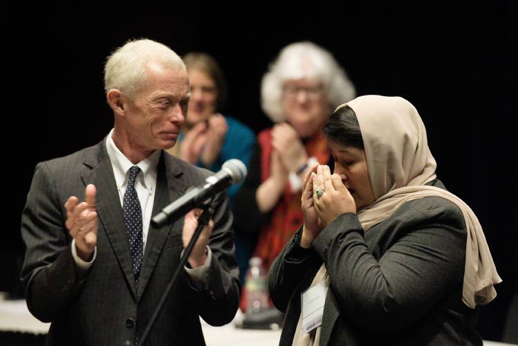 Judge Geeti Roeen, right, collects herself as New Hampshire Supreme Court Justice Gordon MacDonald, left, joins in applauding her at Hanover High School in Hanover, N.H., on Thursday, Jan. 4, 2024. Roeen was an intern in Afghanistan's Supreme Court and worked as a legal consultant for women prisoners before leaving the country with her family in 2021. (Valley News - James M. Patterson) Copyright Valley News. May not be reprinted or used online without permission. Send requests to permission@vnews.com.