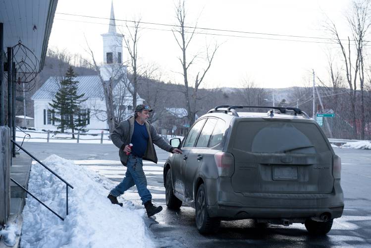 Chris Jones, of East Barnard, returns to his car after a quick stop at the Barnard General Store in Barnard, Vt., in a hurry to finish an apple pruning job on Wednesday, March 13, 2024. “It’s a car killer,” said Jones of the mud on Broad Brook Road where he lives. “These cars are our lifelines.” (Valley News - James M. Patterson) Copyright Valley News. May not be reprinted or used online without permission. Send requests to permission@vnews.com.
