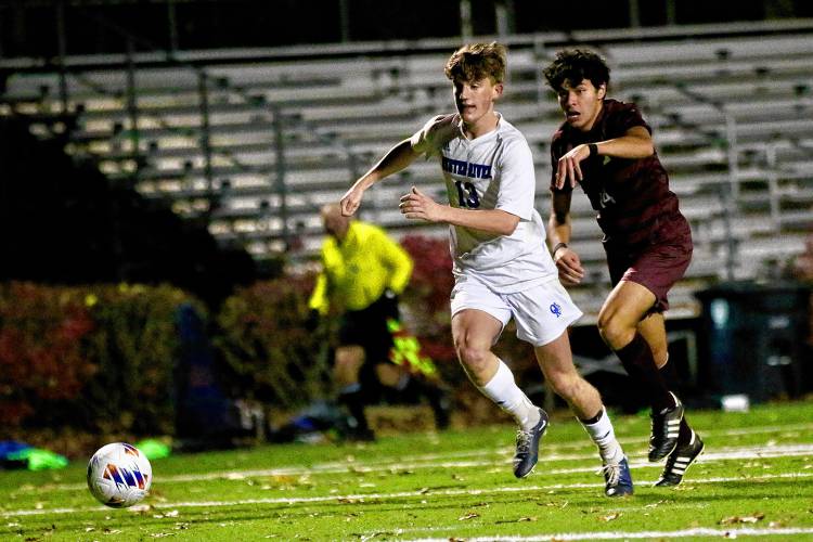Oyster River High's Jack Gill (13) pushes the ball while trailed by Lebanon's Nico Pentella during the NHIAA Division II teams' playoff semifinal on Oct. 31, 2023, at Stellos Stadium in Nashua, N.H. Lebanon won, 1-0. (Valley News - Tris Wykes) Copyright Valley News. May not be reprinted or used online without permission. Send requests to permission@vnews.com