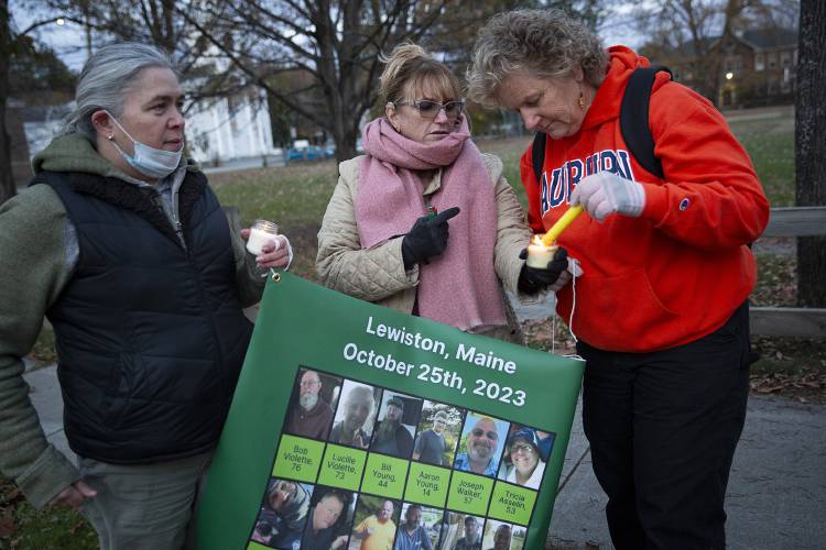 From left, Sheila Loring, of Enfield, N.H., Kara Ghio, of Fairlee, Vt., and Mary Essex, of Norwich, Vt., light candles while holding a banner depicting the victims of the October shooting in Lewiston, Maine, during a vigil organized by members of Gun Sense Vermont on the green in Norwich, Vt., on Thursday, Nov. 2, 2023. The three women, who are all deaf, knew four of the victims who were fellow members of the Deaf community: Bill Brackett, Bryan McFarlane, Joshua Seal and Stephen Vozzella. (Valley News / Report For America - Alex Driehaus) Copyright Valley News. May not be reprinted or used online without permission. Send requests to permission@vnews.com.