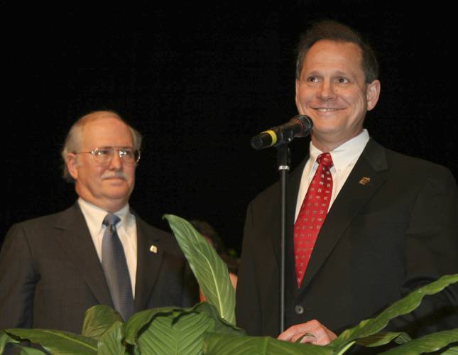 FILE - Tom Parker, left, listens as former Alabama Supreme Court Chief Justice Roy Moore, right, addresses the crowd at the Davis Theater in Montgomery, Ala. on Jan. 14, 2005, before swearing in Parker as an associate justice of the court. When the Alabama Supreme Court ruled that frozen embryos are children, its Chief Justice Tom Parker made explicit use of Christian theology to justify the court's decision in his concurrence, where his language echoed the broader anti-abortion...