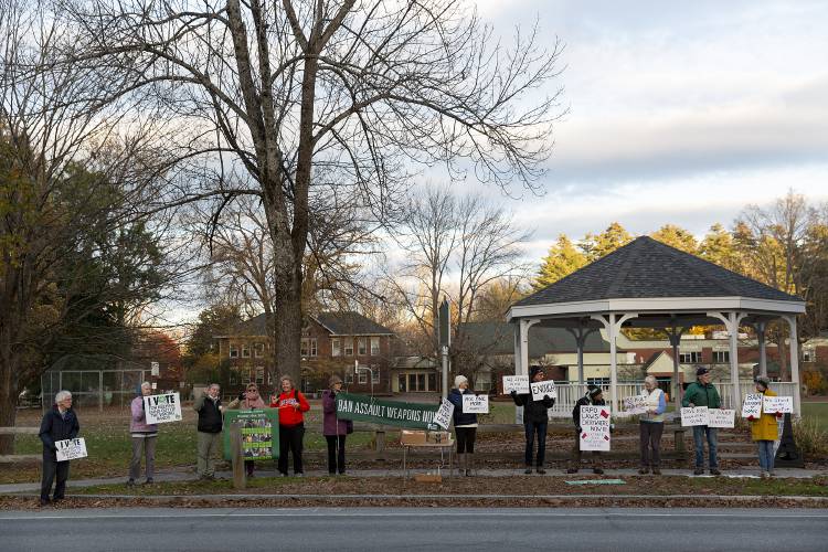 Attendees hold signs and wave to passersby during a vigil organized by members of Gun Sense Vermont honoring the victims of the shooting in Lewiston, Maine, last month on the green in Norwich, Vt., on Thursday, Nov. 2, 2023. (Valley News / Report For America - Alex Driehaus) Copyright Valley News. May not be reprinted or used online without permission. Send requests to permission@vnews.com.