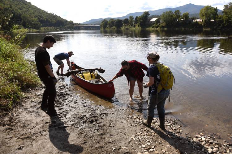 Hypertherm employees Sam Cawley, of Lebanon, N.H., left, James Mudie, his wife Amanda Mudie, of New London, N.H., and Cynthia Chapin, of Lebanon, pull trash and junk out of the Connecticut River on Friday, Sept. 22, 2023, in Cornish, N.H. Working with the Connecticut River Conservancy, employees from Hypertherm were doing a day of service along the river in their September Source to Sea River Cleanup. Balanced on the Mudie's canoe is a vehicle axle, which took the couple two hours to remove from the mud along the river bank. (Valley News - Jennifer Hauck) Copyright Valley News. May not be reprinted or used online without permission. Send requests to permission@vnews.com.