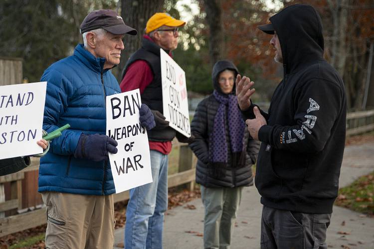 Jason Begnoche, right, of Strafford, Vt., stops to talk to Bob Scobie, left, of West Lebanon, N.H., about his sign during a vigil organized by members of Gun Sense Vermont honoring the victims of the shooting in Lewiston, Maine, last month on the green in Norwich, Vt., on Thursday, Nov. 2, 2023. “I just wanted to hear other people’s thoughts,” said Begnoche, who took issue with the characterization of semiautomatic guns as “weapons of war,” but agreed that it’s important that guns are only available to responsible owners. “You could engage in a dialogue,” Scobie said of the interaction. “That’s what we need.” (Valley News / Report For America - Alex Driehaus) Copyright Valley News. May not be reprinted or used online without permission. Send requests to permission@vnews.com.