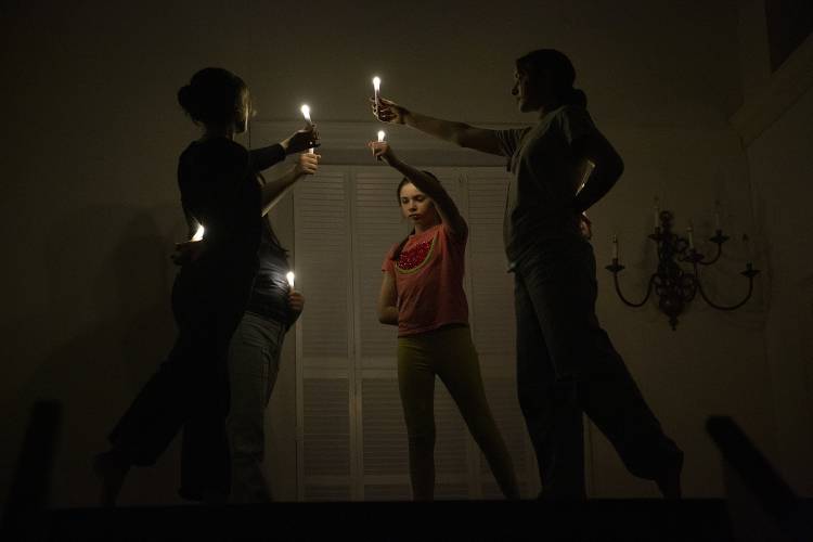 Middle school angels, from left, Della Cote, 13, Evelyn Hayden, 14, Olive Hanissian, 11, and Maddie Pippin, 14, all of Lyme, N.H., hold up candles as they rehearse their routine for the Lyme Christmas Pageant at Lyme Congregational Church on Monday, Nov. 27, 2023. This year marks the 75th anniversary of the pageant, which will be performed on Saturday, December 9, at 7:30 p.m. and Sunday, December 10, at 4:30 p.m. (Valley News / Report For America - Alex Driehaus) Copyright Valley News. May not be reprinted or used online without permission. Send requests to permission@vnews.com.