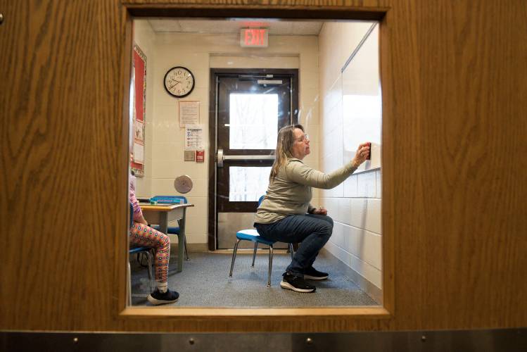 One-on-one paraprofessional Deb Boles works with a student on a math lesson in and entryway that has been converted to a classroom for their use at Sharon Elementary in Sharon, Vt., on Thursday, Nov. 30, 2023. Students and staff traveling between the main school building and a temporary classroom structure nearby often interupt Boles and her student by walking through the space. The Sharon School Board is proposing to renovate and expand the 1989 Sharon Elementary building and replacement the temporary classroom with a permanent, attached structure. (Valley News - James M. Patterson) Copyright Valley News. May not be reprinted or used online without permission. Send requests to permission@vnews.com.