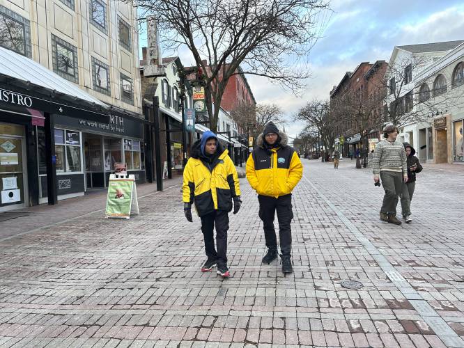 Two security guards walk down the Church Street Marketplace in Burlington, Vt., on Dec. 6, 2023. The city has strengthened security to help shoppers feel safe this holiday season amid concerns about drug activity, gun violence and retail theft. (AP Photo/Lisa Rathke)