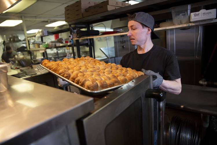 Co-owner Caleb Barr takes a sheet of garlic knots out of the oven at Cantore’s Pizza in West Lebanon, N.H., on Tuesday, April 2, 2024. Barr and Keith Friend, who have each worked at the restaurant for around a decade, took over operation of the business in January. (Valley News / Report For America - Alex Driehaus) Copyright Valley News. May not be reprinted or used online without permission. Send requests to permission@vnews.com.