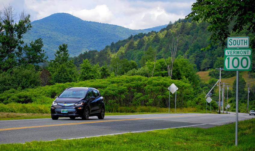 Kevin Jones, of Chittenden, Vt., travels on Route 100 in Stockbridge, Vt., near the Green Mountain National Forest on July 12, 2017. After owning two gas-electric hybrids, Jones decided to lease a Chevy Bolt electric car for his 80-mile roundtrip commute. Because its brakes regenerate the battery power, Jones said the downhill travel in the mountains compensates for its uphill climb. (Photo by Geoff Hansen) 