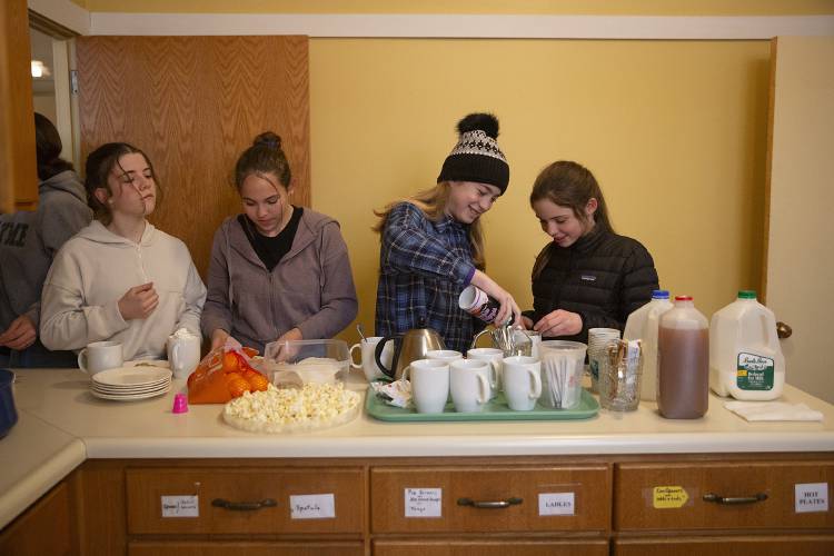 From left, Della Cote, 13, Alice Furstenberg, 13, Isla Cameron, 11, and Olive Hanissian, 11, all of Lyme, N.H., fill up on snacks and hot chocolate before the middle school angels rehearsal for the Lyme Christmas Pageant at Lyme Congregational Church on Monday, Nov. 27, 2023. Angels start rehearsals for the pageant six weeks out, and spend two hours each Monday learning and practicing their routines. (Valley News / Report For America - Alex Driehaus) Copyright Valley News. May not be reprinted or used online without permission. Send requests to permission@vnews.com.