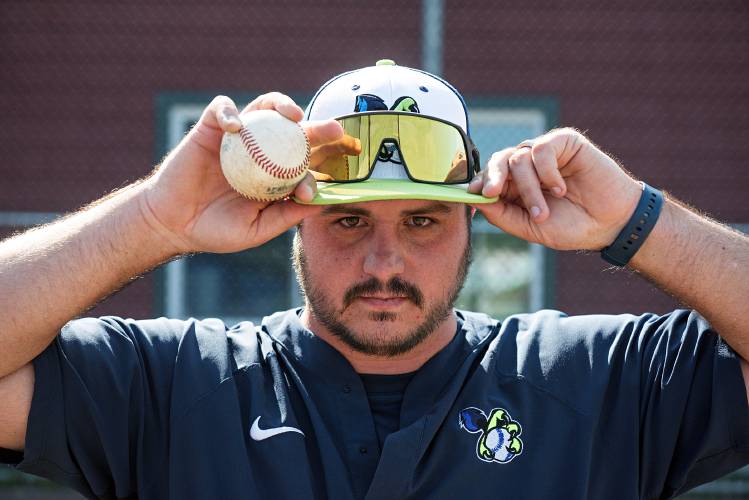 Garrett Nance, assistant baseball coach at East Georgia State College, who joined the Upper Valley Nighthawks as hitting coach this season adjusts his cap before a game with Sanford at Maxfield Sports Complex in Hartford, Vt., on Thursday, July 20, 2023. Nance was a game day operations intern with the team in 2017, operating the scoreboard, acting as mascot and running games between innings. (Valley News - James M. Patterson) Copyright Valley News. May not be reprinted or used online without permission. Send requests to permission@vnews.com.