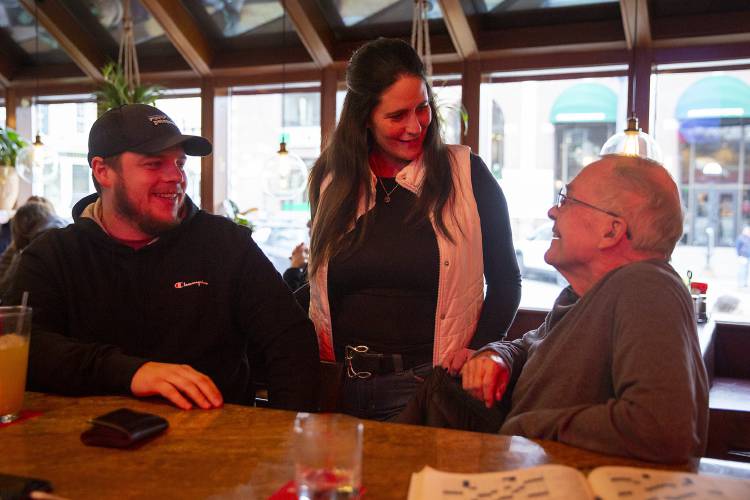 Molly’s owner Jennifer Packard, center, stops to talk to regulars Luke Bellavance, left, of Strafford, Vt., and Dan Leggett, of Hanover, N.H., at Molly's Restaurant & Bar in Hanover, N.H., on Wednesday, Jan. 3, 2024. Packard, who started working at the restaurant as a host almost 30 years ago, took over this week. “I never thought I’d own it,” she said. (Valley News / Report For America - Alex Driehaus) Copyright Valley News. May not be reprinted or used online without permission. Send requests to permission@vnews.com.