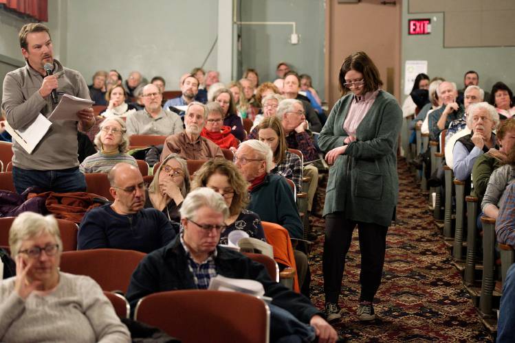 Volunteer Molly Maxham, 16, right, waits to transport the microphone to the next speaker as Jason Drebitko, left, questions the Selectboard during the Woodstock, Vt., Town Meeting Saturday, Feb. 29, 2020. (Valley News - James M. Patterson) Copyright Valley News. May not be reprinted or used online without permission. Send requests to permission@vnews.com.