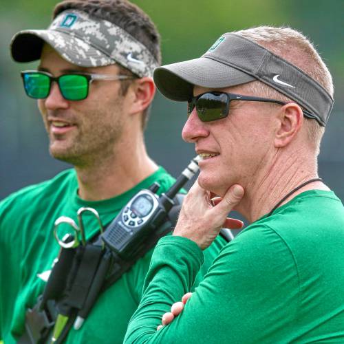 Dartmouth College interim coach Sammy McCorkle, right, watches an Aug. 21, 2023, practice on the Blackman Fields alongside head athletic trainer Ben Schuler. (Valley News - Tris Wykes) Copyright Valley News. May not be reprinted or used online without permission. Send requests to permission@vnews.com.