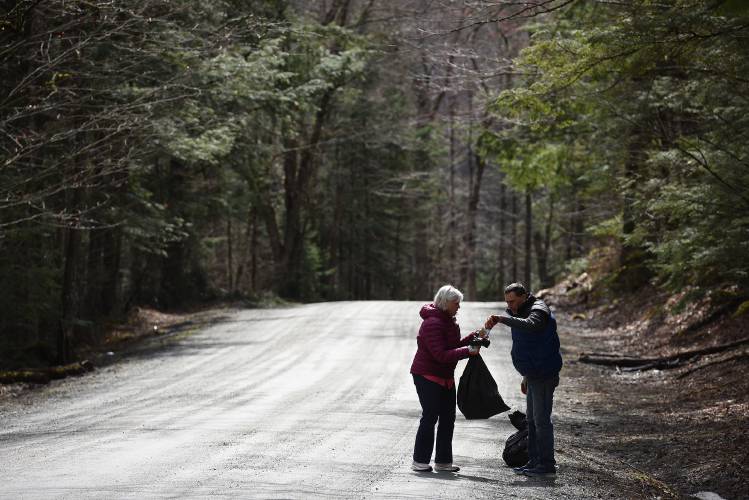 Doreen and Chris Hutchins, of Canaan, N.H,. pick up cans, bottles and other trash along Goose Pond Rd. in Hanover, N.H., on Monday, April 15, 2024. For a number of years the couple has been walking a mile or so down the road this time of year cleaning up what people throw from their cars.  (Valley News - Jennifer Hauck) Copyright Valley News. May not be reprinted or used online without permission. Send requests to permission@vnews.com.