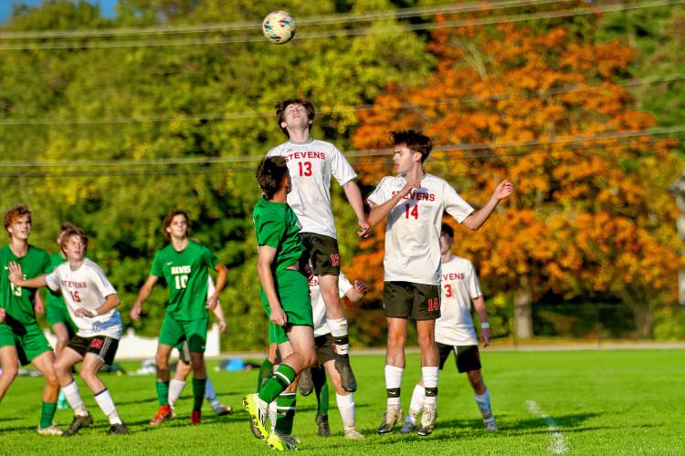 Stevens High's Jackson Fellows (13) heads the ball alongside teammate Josh Howe (14) and behind Hopkinton's Nolan Linstad during the NHIAA Division III teams' first-found playoff game on Oct. 24, 2023, in Hopkinton, N.H. Hopkinton won, 5-0. (Valley News - Tris Wykes) Copyright Valley News. May not be reprinted or used online without permission. Send requests to permission@vnews.com.
