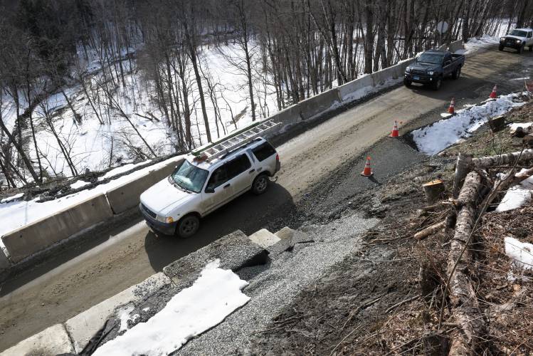 Concrete barriers mark the edge of a landslide below Broad Brook Road in Royalton, Vt., on Thursday, Feb. 22, 2024. The reopened to one lane of traffic on January 12, after being closed since July. (Valley News - James M. Patterson) Copyright Valley News. May not be reprinted or used online without permission. Send requests to permission@vnews.com.