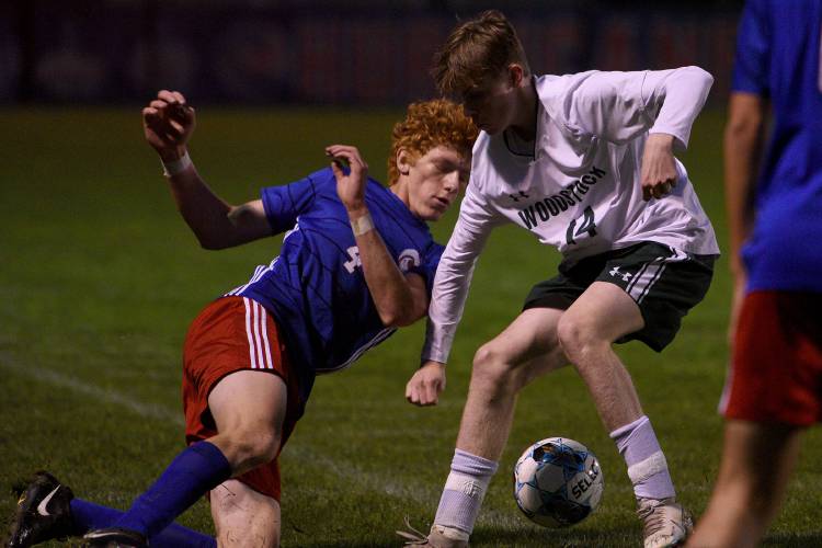 Hartford's Cavan Benjamin goes down with Woodstock's Reid Allegretti while battling for control of the ball during their game on Wednesday, Oct. 11, 2023, in White River Junction, Vt. Hartford won, 3-1.   (Valley News - Jennifer Hauck) Copyright Valley News. May not be reprinted or used online without permission. Send requests to permission@vnews.com.