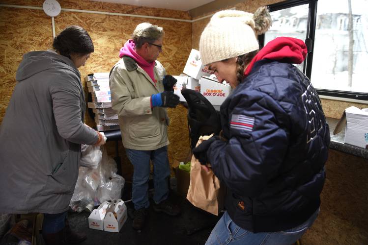 Sunapee Town Manager Shannon Martinez, right, works with fellow town employees Allyson Traeger and Kris McAllister to bring soup donated by Shaws to emergency workers at the scene of a structure fire in Sunapee, N.H., on Friday, Jan. 19, 2024. The fire displaced all of the residents in the building in Georges Mills, a village of Sunapee. (Valley News - Jennifer Hauck) Copyright Valley News. May not be reprinted or used online without permission. Send requests to permission@vnews.com.