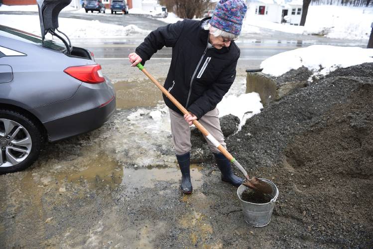 Jean Wolstenholme, of Thetford, Vt., said she was expecting her driveway to be icy after recent rain and was filling  a couple of buckets at the town sand pile on Wednesday, Jan. 10, 2024. (Valley News - Jennifer Hauck) Copyright Valley News. May not be reprinted or used online without permission. Send requests to permission@vnews.com.