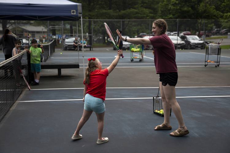 Emma Woloshin, Youth Program Services Coordinator, right, high fives Lily Scott, 7, of Lebanon, N.H., while they play tennis during the Special Needs Support Center’s Camp Aspire at Storrs Pond Recreation Area in Hanover, N.H., on Thursday, June 29, 2023. The summer camp is an extension of SNSC’s year-round Aspire program, which is designed to give school-aged children with disabilities a sensory-friendly space to participate in activities and practice building social skills. (Valley News / Report For America - Alex Driehaus) Copyright Valley News. May not be reprinted or used online without permission. Send requests to permission@vnews.com.