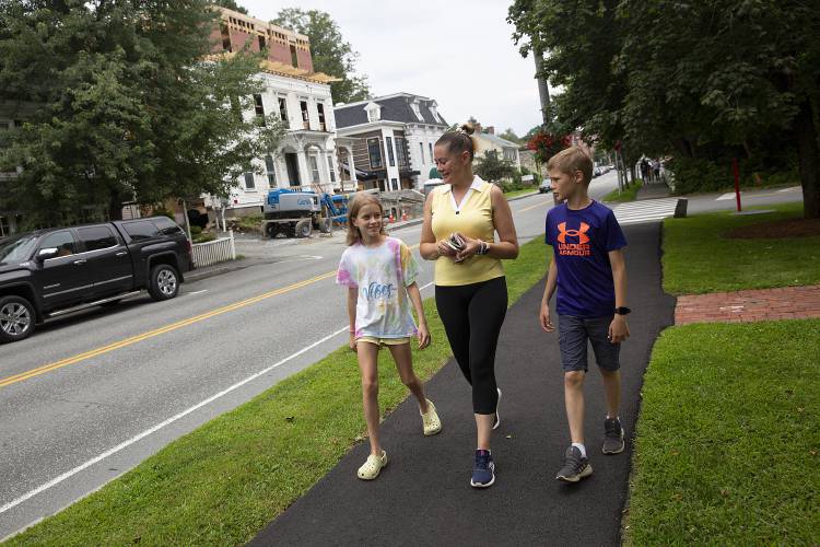 Iryna Burtolik, center, walks down the street with her children, Anya, 10, left, and Hlieb, 11, after dropping off a package at the post office in Woodstock, Vt., on Thursday, August 10, 2023. Burtolik and Antonina Reznichenko have been borrowing their sponsors’ car to get around, but a recent successful fundraiser will enable them to have a vehicle of their own so they can run errands and have reliable transportation to their jobs when they are able to find work. (Valley News / Report For America - Alex Driehaus) Copyright Valley News. May not be reprinted or used online without permission. Send requests to permission@vnews.com.
