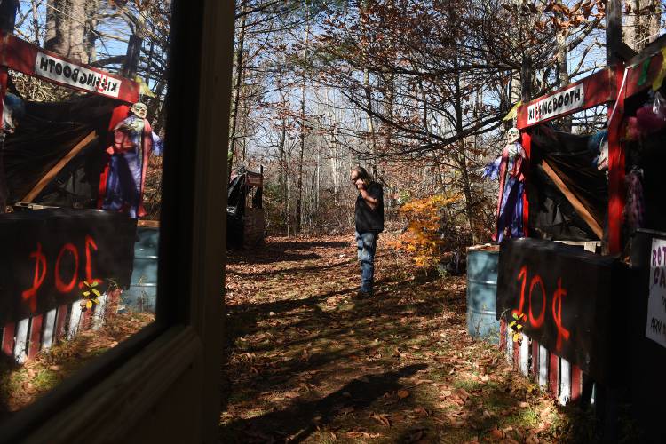 Bruce Clough takes a call when walking through his creation Devil's Playground and Haunted Walk in Unity, N.H., at his home on Thursday, Oct. 27, 2022. The walk snakes though the woods with creepy stops like the Doll House and Trailer Park. (Valley News - Jennifer Hauck) Copyright Valley News. May not be reprinted or used online without permission. Send requests to permission@vnews.com.