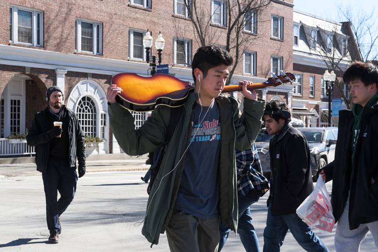 Ethan Kong, center, walks to class at Dartmouth College carrying his Epiphone Viola Bass in Hanover, N.H., Feb. 19, 2024. Kong, who is from Okinawa, Japan, said he’s looking for a band to play with. He has no time to practice at home, so he takes the instrument with him to play wherever he can. (Valley News - James M. Patterson) Copyright Valley News. May not be reprinted or used online without permission. Send requests to permission@vnews.com.