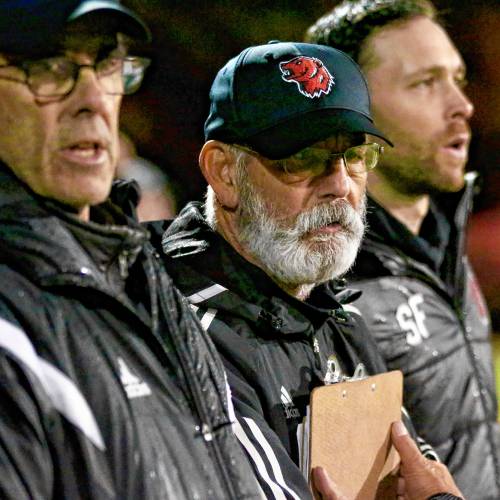 Hanover High boys soccer head coach Rob Grabill, center, watches his NHIAA Division I team play Manchester Central in the playoff semifinals on Oct. 30, 2023, at Stellos Stadium in Nashua, N.H. Assistant coach Ben Snyder, left, and associate head coach Sam Farnham flak Grabill, whose team won, 2-0. (Valley News - Tris Wykes) Copyright Valley News. May not be reprinted or used online without permission. Send requests to permission@vnews.com.