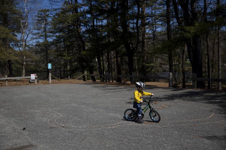 Camden Reney, 3, of Lebanon, N.H., practices biking around a chalk track drawn by his mother Felicia Reney at Kilowatt Park North in Wilder, Vt., on Tuesday, April 9, 2024. Great River Hydro owns the 80-plus acre plot along the Connecticut River that makes up the park, and Hartford is asking the company to provide maintenance fees that are currently covered by the town, as well as an annual $120,000 contribution to a capital reserve fund for improvements. (Valley News / Report For America - Alex Driehaus) Copyright Valley News. May not be reprinted or used online without permission. Send requests to permission@vnews.com.