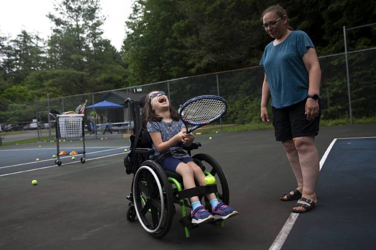 Valeria Somoff, 8, of Lebanon, N.H., laughs while playing tennis with her one-on-one aide Carrie Moote, of White River Junction, Vt., during the Special Needs Support Center’s Camp Aspire at Storrs Pond Recreation Area in Hanover, N.H., on Thursday, June 29, 2023. (Valley News / Report For America - Alex Driehaus) Copyright Valley News. May not be reprinted or used online without permission. Send requests to permission@vnews.com.