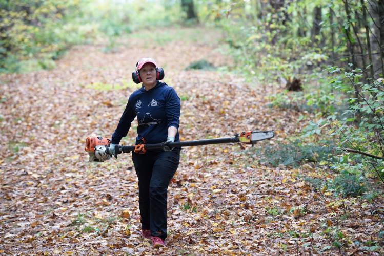 Hartland Winter Trails Executive Director Andrea Ambros cuts back brush during a volunteer work day to maintain the corridor of the more than 25 kilometers of trail the organization maintains for cross country ski and snowshoe travel in Hartland, Vt., on Wednesday, Oct. 18, 2023. 
