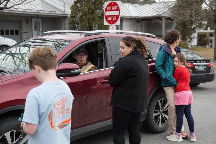 A woman who declined to identify herself, center, apologizes to school crossing guard Willie Downing, 87, second from left, on Monday afternoon, March 4, 2024, near Mount Lebanon Elementary in West Lebanon, N.H. Downing was struck by a vehicle while controlling traffic during morning drop-off at the intersection of White Ave. and Highland Ave. He was talking with Faye Gillespie, and her daughter Maggie, 7, right, and John Stone, 11, and his mother Jenny Armstrong, about the incident when the woman approached to speak to him. She did not admit to hitting Downing. (Valley News - James M. Patterson) Copyright Valley News. May not be reprinted or used online without permission. Send requests to permission@vnews.com.