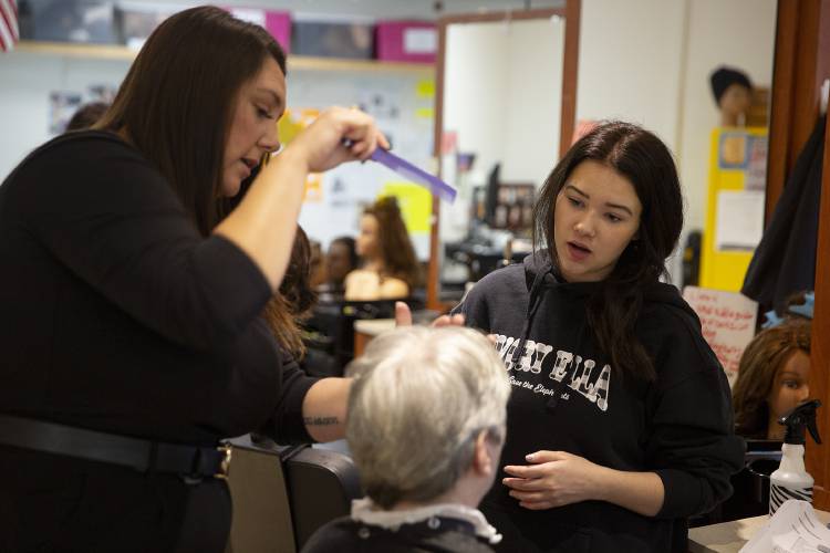 Cosmetology instructor Lorraine Kennedy, left, explains how to cut a client’s bangs to Oxbow senior Abigail Hathaway, 18, of Corinth, Vt., during a class at River Bend Career and Technical Center in Bradford, Vt., on Wednesday, Dec. 6, 2023. The school recently expanded its cosmetology program to ensure that students complete the 1,000 training hours required to obtain a license in Vermont, allowing students to graduate into the workforce without debt from additional training programs. (Valley News / Report For America - Alex Driehaus) Copyright Valley News. May not be reprinted or used online without permission. Send requests to permission@vnews.com.