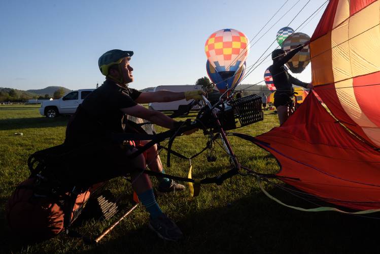 Chris Ritland, of Quechee, fills his balloon with hot air in preparation to take Annika Ringen, right, on her first flight at the Post Mills, Vt., Airport during the Experimental Balloon and Airship Association Meet on Saturday, May 14, 2022. Ritland said the meet is a relaxed gathering for pilots who have built their own balloons to exchange ideas and techniques, and was instrumental in sparking his interest in hot air balloons. 