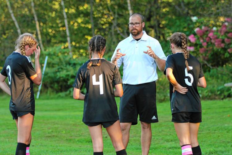 Sharon Academy girls soccer coach Ben Diller speaks with, from left, MaCallister Gray, Natalie Young and Maddy Mintz during the Phoenix's Vermont Division IV game against Poultney on Oct. 3, 2023, in Sharon, Vt. Poultney won, 7-3. (Valley News - Tris Wykes) Copyright Valley News. May not be reprinted or used online without permission. Send requests to permission@vnews.com.