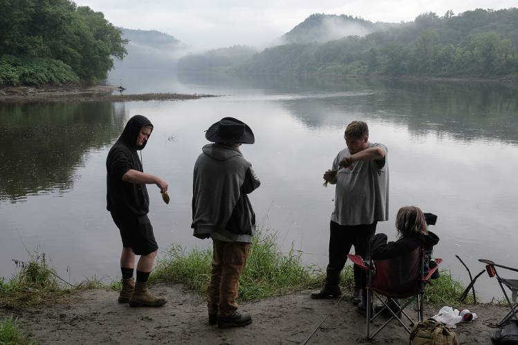 Tobyn Von Kahle, second from right, removes a hook from a sunfish as Corban Williams, left, prepares to throw another back into the water at the confluence of the Sugar and Connecticut Rivers in Clarmeont, N.H., on Monday, August 7, 2023. The friends, from left, Williams, who leaves for Army basic training in September, Joseph Garrow, Tobyn Von Kahle, and Karisma Remick, all of Claremont, said they started early Monday and fished at a couple different locations before mosquitos became too overwhelming in the evening. (Valley News - James M. Patterson) Copyright Valley News. May not be reprinted or used online without permission. Send requests to permission@vnews.com.