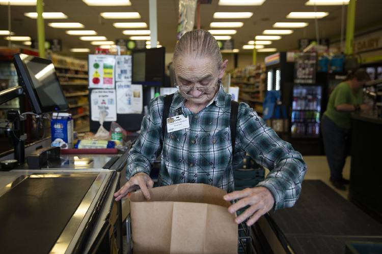 Evelyn Adams, 69, of White River Junction, Vt., bags groceries for a customer at the Co-op Food Store in White River Junction on Friday, August 25, 2023. Adams has worked at the store for over a decade, starting at P&C Market before it was taken over by the co-op. (Valley News / Report For America - Alex Driehaus) Copyright Valley News. May not be reprinted or used online without permission. Send requests to permission@vnews.com.
