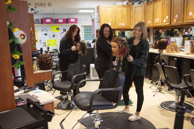 From left, seniors Leah Hathaway, 17, of West Topsham, Vt., Iris Morand, 18, of Hartland, Vt., and Skylar Welch, 17, of Woodsville, N.H., participate in a cosmetology class at River Bend Career and Technical Center in Bradford, Vt., on Wednesday, Dec. 6, 2023. Demand has increased for the cosmetology program, which currently includes 15 students total, and River Bend is looking into ways to fund an expansion of the classroom space, including an additional salon entrance for clients. (Valley News / Report For America - Alex Driehaus) Copyright Valley News. May not be reprinted or used online without permission. Send requests to permission@vnews.com.