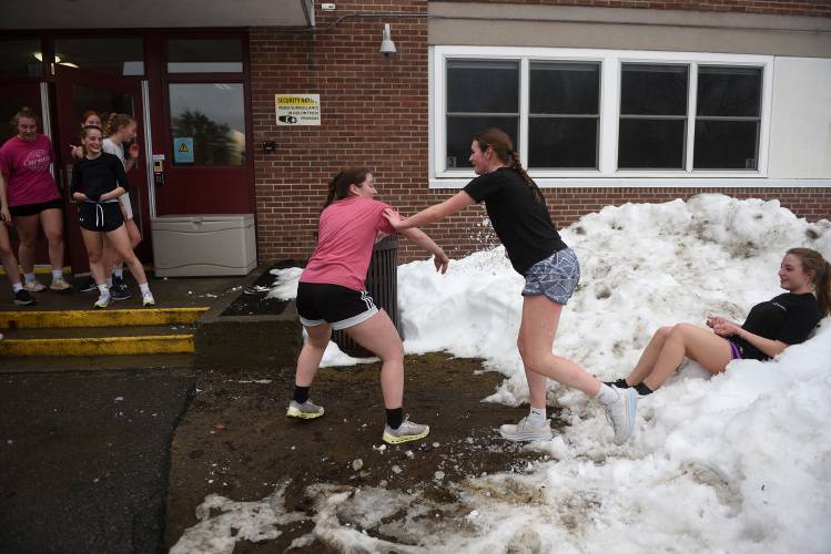After finishing practice with sprints and stair climbing, Lebanon lacrosse players Sara Forman, left, and Biff Maher chase one another with snow while Addison Durell cools down in a snowbank on Wednesday, March 28, 2024, in Lebanon, N.H. (Valley News - Jennifer Hauck) Copyright Valley News. May not be reprinted or used online without permission. Send requests to permission@vnews.com.