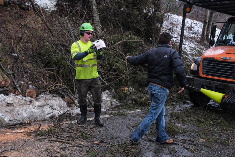 An Etna resident, who declined to be identified, right, hands off a box of donuts to Asplundh tree worker Dylan, who only gave his first name, left, on Trescott Road in Etna, N.H., on Saturday, Jan. 13, 2024. Damaging winds swept over the Upper Valley on Saturday, keeping emergency and utility crews busy removing downed trees over roadways and restoring power. (Valley News - James M. Patterson) Copyright Valley News. May not be reprinted or used online without permission. Send requests to permission@vnews.com.